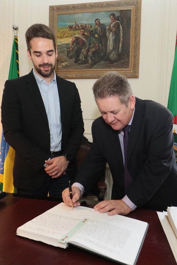 Ranol Vieira Júnior, ao lado de Eduardo Leite, assina documento de transmissão para o cargo de governador em exercício.