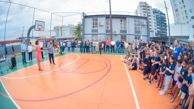 Alunos e professores reunido em quadra esportiva escolar