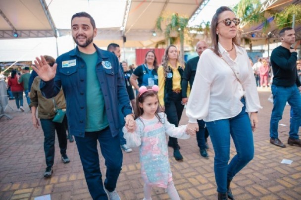 Gabriel Souza ao lado da filha e da esposa, cumprimentando as pessoas na festa do peixe 
