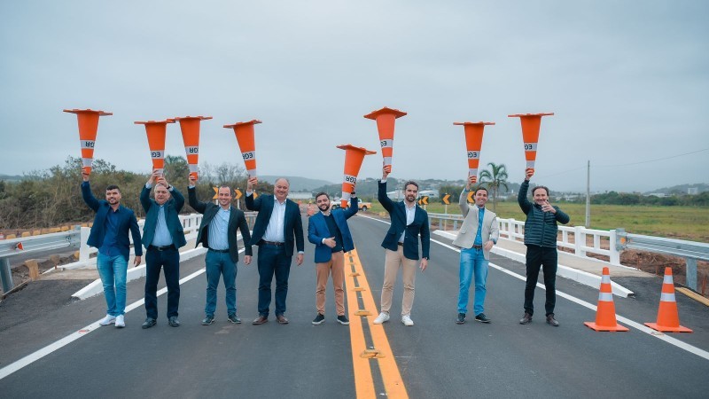 Vice-governador, governador e lideranças seguram cones na ponte sendo entregue