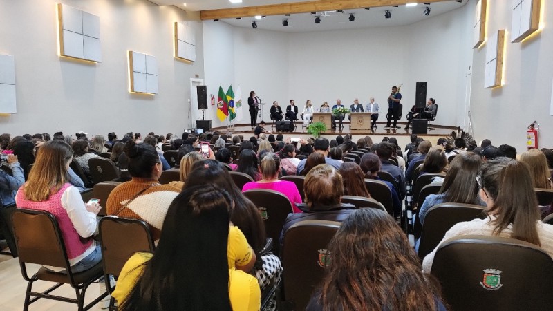 Grupo de pessoas assiste a palestra em auditório