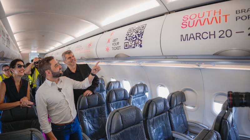 Pessoas conferem marca do South Summit Brazil na parte interna de avião da companhia Azul