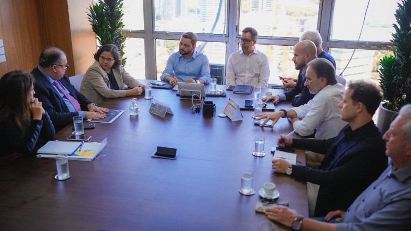 Grupo de pessoas reunido ao redor de uma mesa