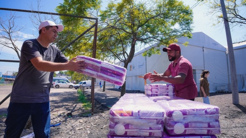 Dois homens transportando doações para Centros de Acolhimento em outubro de 2024.