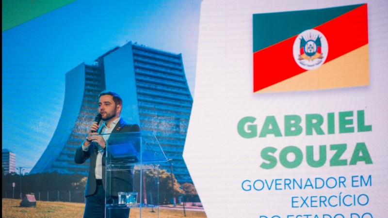 Gabriel atrás de um púlpito transparente falando durante a abertura do Décimo Segundo Cosud.