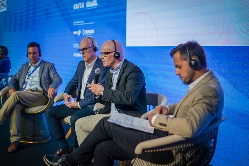 Tomazeli sentado rodeado de mais três pessoas em um painel no Gov Expo Summit 2024