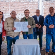 Foto mostra o vice-governador Gabriel Souza segurando o documento assinado com o prefeito. Outras autoridades est&atilde;o juntos na foto e aplaudem o ato.